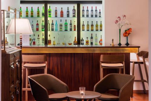 a bar with two chairs and a table and some bottles at Vila Vicência in Funchal