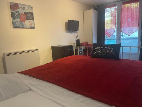 a bedroom with a bed with a red blanket and a window at Chambres d'Hôtes Poirier Bazin in Montry