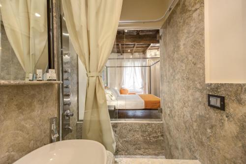 a bathroom with a toilet and a bed at Casa Argileto in Rome