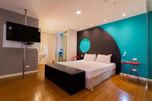 a bedroom with a large bed and a flat screen tv at Lobie Queen Ipanema in Rio de Janeiro