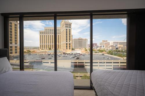 a bedroom with a bed and a view of a city at Stay Together Suites in Las Vegas