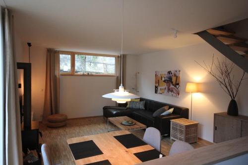 a living room with a black couch and a table at An der Kirchtreppe in Blankenburg