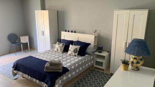 1 dormitorio con 1 cama con almohadas azules y lámpara en APARTAMENTO FONTE DO CRISTO, en Porriño