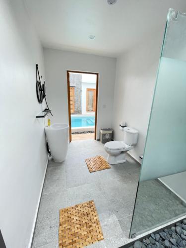 a bathroom with a shower and a toilet and a sink at Moringa Resort with Pool, open Air Shower & shared Bath sleeps 8 in Willemstad