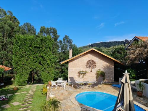 un patio trasero con piscina y una casa en Chalés Valle Florido, en Monte Verde