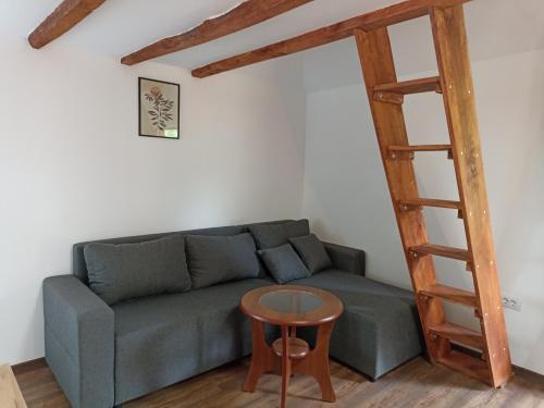 a living room with a couch and a wooden ladder at Ranč Sretenović in Mionica