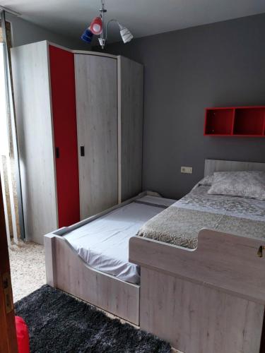 1 dormitorio con 1 cama y armario rojo y blanco en O recuncho do xeixido, en A Coruña