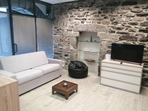 Una sala de estar con un sofá blanco y un televisor. en LOFT AZZURRA, en Cannobio