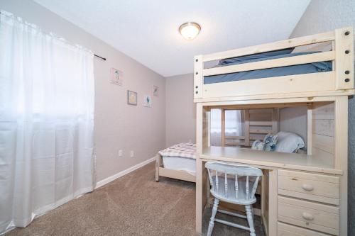 1 dormitorio con litera y escritorio con silla en Forever Summer - Entire House! with KING Bed!, en Clearwater