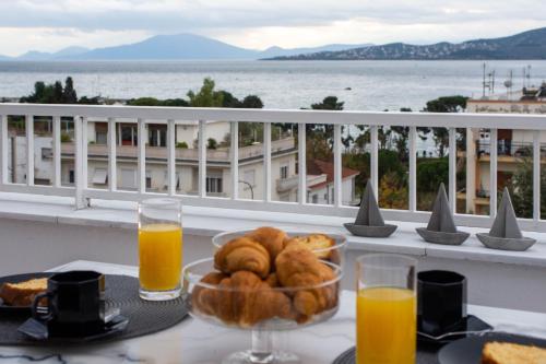 a table with a bowl of food and orange juice at Sea View luxury apartment in Volos