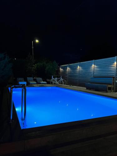 a swimming pool at night with blue illumination at Pool Garden-Oaza in Skopje