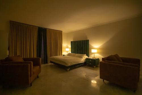 une chambre d'hôtel avec un lit et deux chaises dans l'établissement شاليه خاص, à Riyad