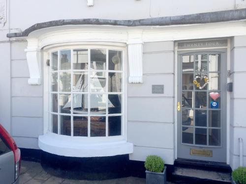 a white house with a window and a door at Beautiful Seaside one bedroom apartment in Shaldon