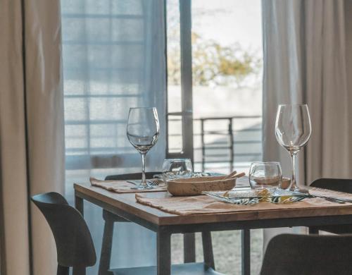 a wooden table with wine glasses on top of it at Aires de Sierra in Merlo