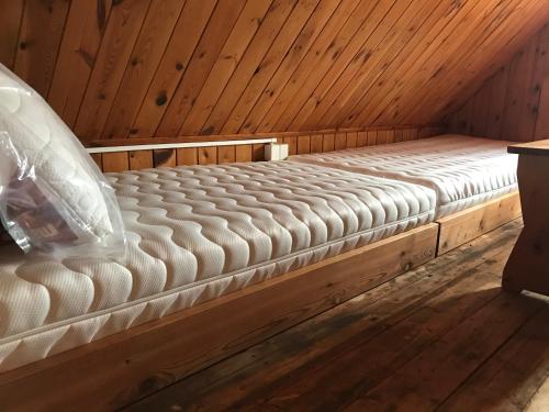 a mattress bed sitting inside of a wooden cabin at Chata Florián in Stráž