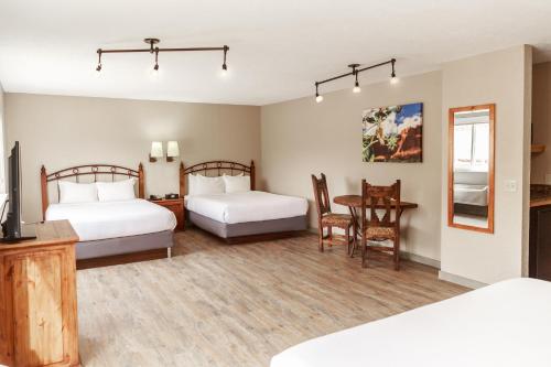 a bedroom with two beds and a table with a dining room at Aarchway Inn in Moab