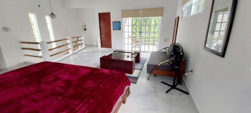 a bedroom with a red bed and a desk at NEW! CASA XOLA Cenote and Fauna Loft in Cozumel