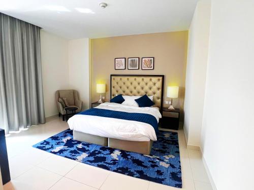 a bedroom with a large bed and a blue rug at Lovely one bedroom apartment with world class hotel amenities in Dubai