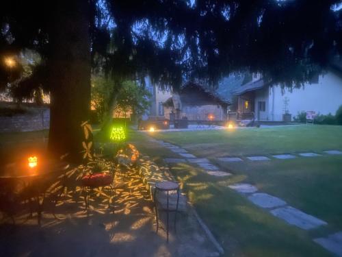 a table and chairs sitting under a tree at night at Cuore Alpino in Olivone