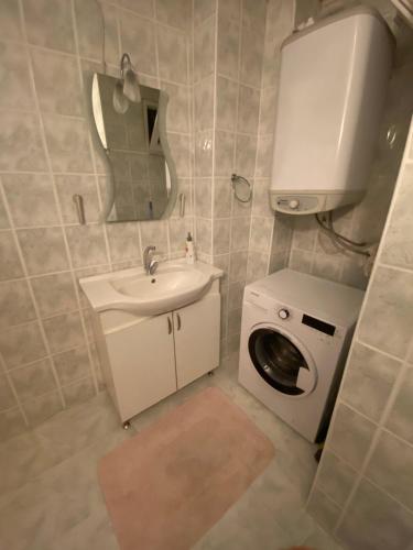 a bathroom with a sink and a washing machine at Balcı Apart in Çanakkale
