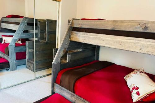 a bedroom with two bunk beds and a mirror at Ski and Hike Mtn-View Condo in Silverthorne! in Silverthorne