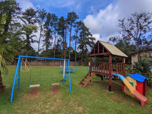 un parque infantil con tobogán y columpio en El Rosedal Cataratas en Puerto Iguazú