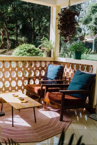 two chairs and a coffee table on a porch at Mkoani Homestay in Moshi