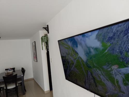 a large flat screen tv hanging on a wall at A minutos del centro Con cochera in Trujillo