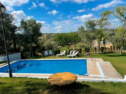 a pool with a table and chairs in a yard at Casa rural La Portilla in Aroche