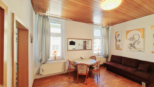 ein Wohnzimmer mit einem Tisch und einem Sofa in der Unterkunft ELENA flat Tulpe Duisburg Zentrum in Duisburg