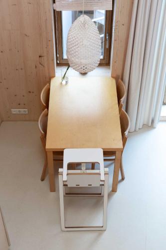 a dining room table with a white chair and a lamp at Noorderbed in Amsterdam