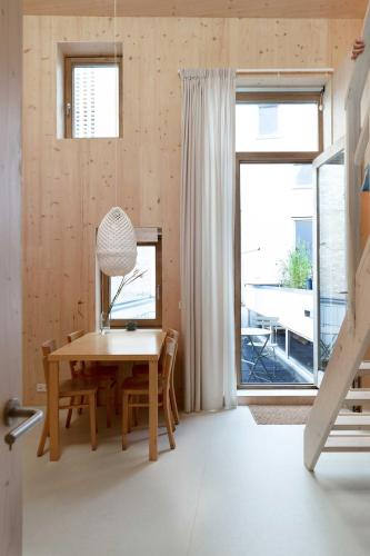 a dining room with a table and a window at Noorderbed in Amsterdam