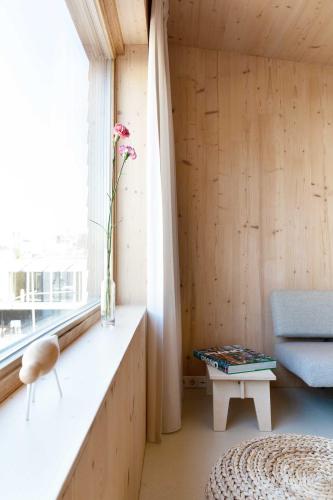 a room with a bench and a table and a window at Noorderbed in Amsterdam