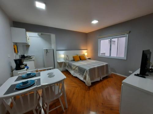 a bedroom with a bed and a table and a kitchen at Descanse em Lindo Studio na Bela Vista em São Paulo in Sao Paulo