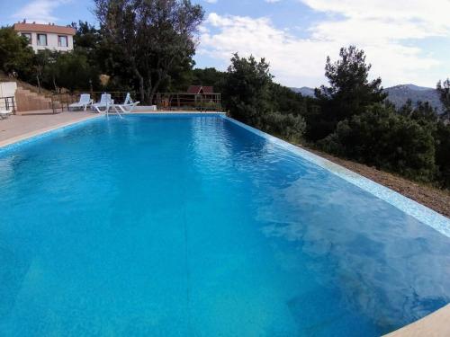 a large blue swimming pool in a house at Gödence Hotel Restoran Bungalow in Gödence