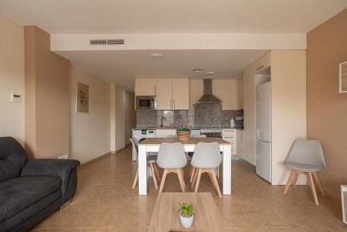 cocina y sala de estar con mesa y sillas en Nuevo apartamento en playa con aire acondicionado MASBO 3, en Moncófar