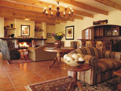 a living room with a couch and a fireplace at Altes Landhaus Country Lodge in Oudtshoorn