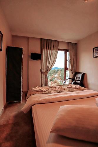 a bedroom with two beds and a window at Gödence Hotel Restoran Bungalow in Gödence