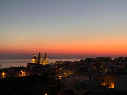 a view of a city at sunset at Newly Refurbished Mellieha Central apartment in Mellieħa