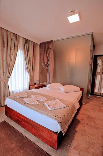 a bedroom with a large bed in front of a window at Gödence Hotel Restoran Bungalow in Gödence