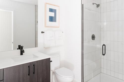 a white bathroom with a toilet and a shower at Sonder The Opal in Chicago