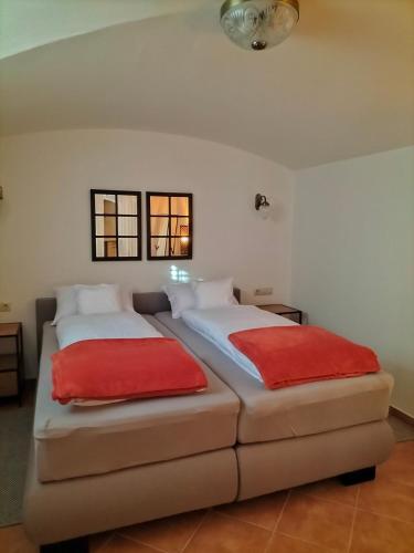 a bedroom with two beds with red pillows at Sakura Apartment in Mosonmagyaróvár