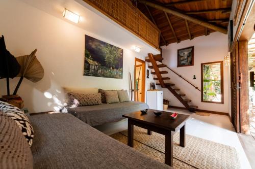 uma sala de estar com um sofá e uma mesa em Bangalôs Meu Jardim Caraíva em Caraíva