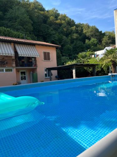 - une piscine en face d'une maison avec un dauphin dans l'eau dans l'établissement CASA STEFANIA con giardino a LUGANO, à Grancia