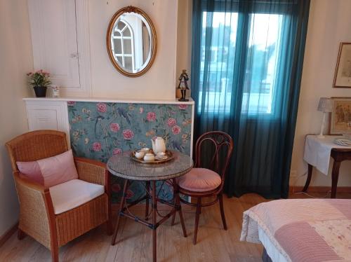 謝爾河畔聖喬治的住宿－Chez Lili，配有桌椅和镜子的客房