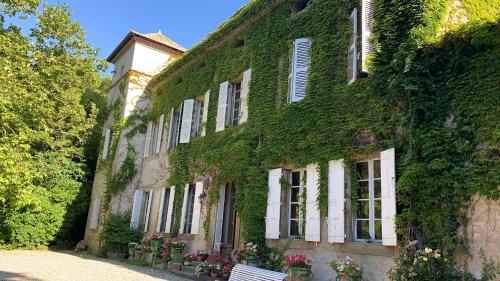 an ivy covered building with a bench in front of it at La Belle Eco in Montréal