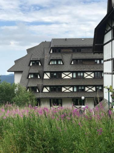 a building with a gray roof and purple flowers at Kopaonik Župa 505 in Kopaonik