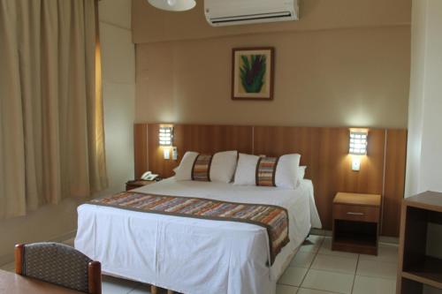 Mato Grosso Palace Hotel في كويابا: غرفه فندقيه سرير وتلفزيون