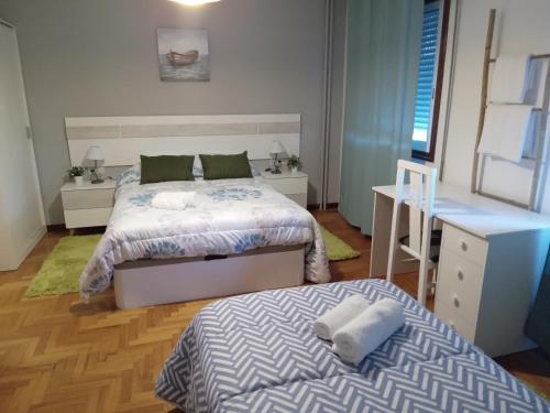 a bedroom with two beds and a desk at Casa Navarro in Vigo