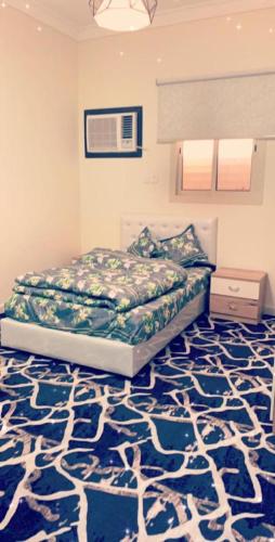 um quarto com uma cama e um tapete azul em شقق العزاب الفاخرة em Tabuk